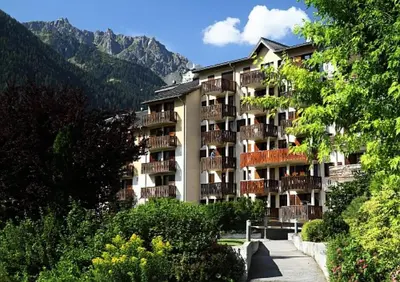 a large apartment building with balconies in the mountains at Résidence La Rivière - maeva Home - Appartement 2 pièces 6 personnes - Sélection MAE-8671 in Chamonix-Mont-Blanc