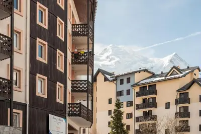 a group of buildings with a mountain in the background at Résidence La Rivière - maeva Home - Appartement 2 pièces 6 personnes - Sélection MAE-8671 in Chamonix-Mont-Blanc