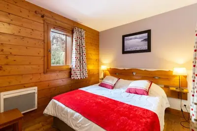 a bedroom with a bed with a red blanket at Résidence Les Fermes du Soleil - maeva Home - Appartement 3 pièces 6 personnes - Sélection MAE-8004 in Les Carroz d'Araches