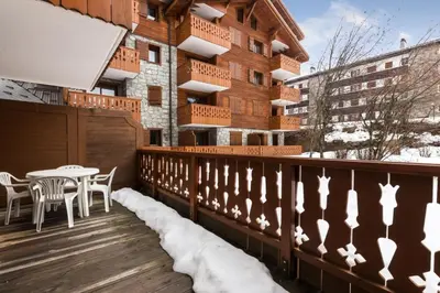 a balcony with a table and chairs and a building at Résidence Les Fermes du Soleil - maeva Home - Appartement 3 pièces 6 personnes - Sélection MAE-8004 in Les Carroz d'Araches