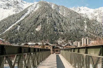 a bridge over a city with a mountain in the background at Résidence La Ginabelle - maeva Home - Appartement 2 Pièces 4 Personnes - Sélection MAE-9584 in Chamonix-Mont-Blanc