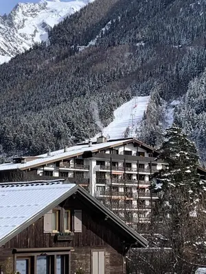a town covered in snow with mountains in the background at Résidence La Ginabelle - maeva Home - Appartement vue mont blanc 3 pièces 6 personnes avec parking - Prestige MAE-8604 in Chamonix-Mont-Blanc