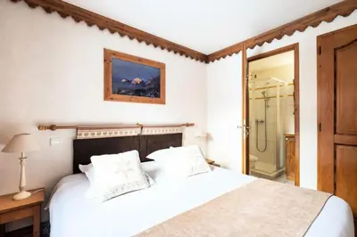 a bedroom with a white bed and a shower at Résidence La Ginabelle - maeva Home - Appartement 3 pièces 6 personnes - Prestige MAE-3904 in Chamonix-Mont-Blanc