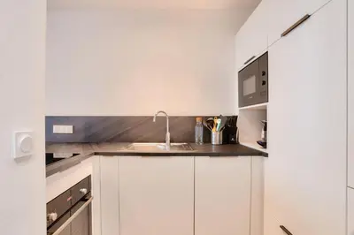 a kitchen with white cabinets and a sink at L'Aiguille - maeva Home - 2 Pièces 4 Personnes Prestige MAE-0414 in Chamonix-Mont-Blanc