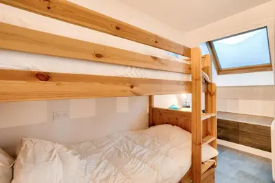 a bedroom with two bunk beds and a window at L'Aiguille - maeva Home - 2 Pièces 4 Personnes Prestige MAE-0414 in Chamonix-Mont-Blanc