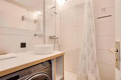 a washing machine in a bathroom with a shower at L'Aiguille - maeva Home - 2 Pièces 4 Personnes Prestige MAE-0414 in Chamonix-Mont-Blanc