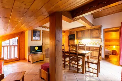 a living room with a table and a dining room at Résidence Les Fermes du Soleil - maeva Home - Appartement 3 pièces 5 personnes - Sélection MAE-9504 in Les Carroz d'Araches
