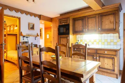a kitchen with a wooden table and wooden cabinets at Résidence Les Fermes du Soleil - maeva Home - Appartement 3 pièces 5 personnes - Sélection MAE-9504 in Les Carroz d'Araches