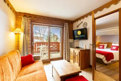 a hotel room with a bed and a balcony at Résidence Les Fermes du Soleil - maeva Home - Appartement 3 pièces 6 personnes - Sélection MAE-8007 in Les Carroz d'Araches