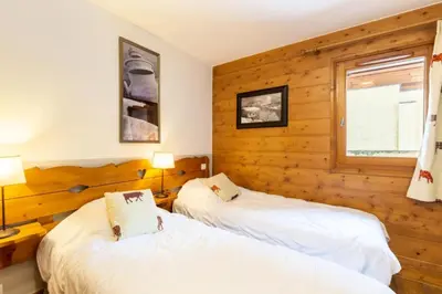 two beds in a room with wooden walls at Résidence Les Fermes du Soleil - maeva Home - Appartement 3 pièces 6 personnes - Sélection MAE-8007 in Les Carroz d'Araches