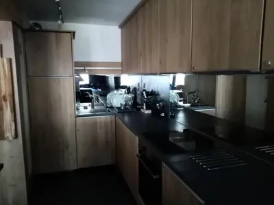 a kitchen with black counter tops and wooden cabinets at Résidence La Ginabelle - maeva Home - 4 Pièces 6 Personnes - Prestige MAE-1506 in Chamonix-Mont-Blanc