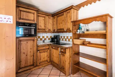 a kitchen with wooden cabinets and a stove top oven at Résidence La Ginabelle - maeva Home - 4 Pièces 6 Personnes - Prestige MAE-1506 in Chamonix-Mont-Blanc