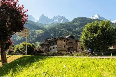 a person riding a bike in front of a house at Résidence La Ginabelle - maeva Home - 4 Pièces 6 Personnes - Prestige MAE-1506 in Chamonix-Mont-Blanc