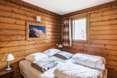 a bedroom with two twin beds in a log cabin at Résidence La Ginabelle - maeva Home - 4 Pièces 6 Personnes - Prestige MAE-1506 in Chamonix-Mont-Blanc