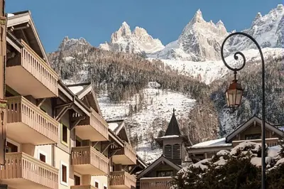 a view of a snow covered mountain with buildings and a street light at Résidence La Ginabelle - maeva Home - Appartement 3 Pièces 6 Personnes - Prestige MAE-2304 in Chamonix-Mont-Blanc