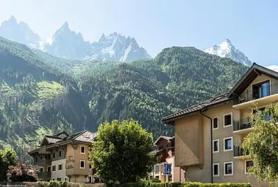 a group of buildings with mountains in the background at Résidence La Ginabelle - maeva Home - Appartement 3 Pièces 6 Personnes - Prestige MAE-2304 in Chamonix-Mont-Blanc