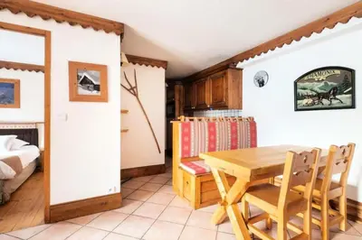 a dining room with a table and a bed at Résidence La Ginabelle - maeva Home - Appartement 3 Pièces 6 Personnes - Prestige MAE-2304 in Chamonix-Mont-Blanc