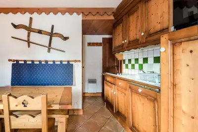 a kitchen with wooden cabinets and a wooden table at Résidence Les Fermes du Soleil - maeva Home - 3 Pièces 6 Personnes Sélection MAE-4102 in Les Carroz d'Araches