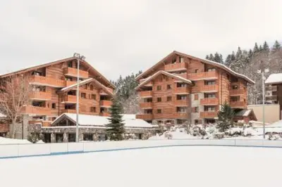 a large apartment building with a rink in front of it at Résidence Les Fermes du Soleil - maeva Home - 3 Pièces 6 Personnes Sélection MAE-4102 in Les Carroz d'Araches