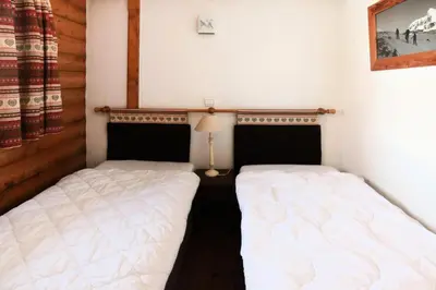 two twin beds in a bedroom with a lamp at Résidence La Ginabelle - maeva Home - 4 Pièces 6 Personnes Sélection MAE-5671 in Chamonix-Mont-Blanc