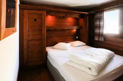 a bedroom with a bed with white sheets and pillows at Résidence La Ginabelle - maeva Home - 4 Pièces 6 Personnes Sélection MAE-5671 in Chamonix-Mont-Blanc