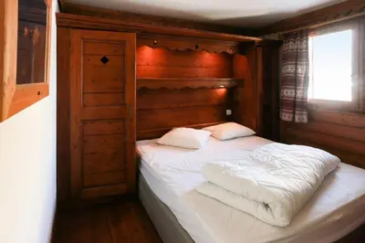 a bedroom with a bed with white sheets and pillows at Résidence La Ginabelle - maeva Home - 4 Pièces 6 Personnes Sélection MAE-5671 in Chamonix-Mont-Blanc