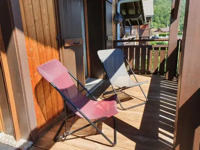 two chairs sitting on the porch of a house at Le Clos B11 - 3 bedroom apartment 5 minutes walk to the square in Samoëns