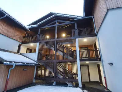 a building with a balcony with snow on the ground at Le Clos B11 - 3 bedroom apartment 5 minutes walk to the square in Samoëns