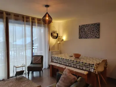 a living room with a table and a chair at Le Clos B11 - 3 bedroom apartment 5 minutes walk to the square in Samoëns