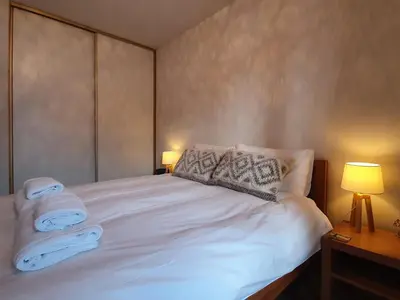 a bedroom with a white bed with two towels on it at Le Clos B11 - 3 bedroom apartment 5 minutes walk to the square in Samoëns