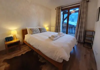 a bedroom with a large bed with towels on it at Le Clos B11 - 3 bedroom apartment 5 minutes walk to the square in Samoëns