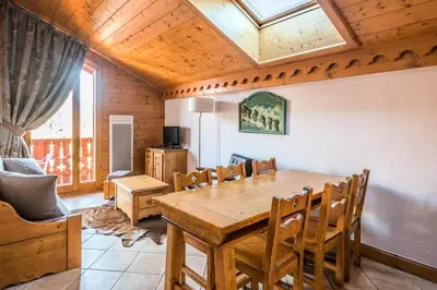 a dining room with a wooden table and chairs at Résidence Les Fermes du Soleil - maeva Home - Appartement 4 pièces 7 personnes Selection MAE-0493 in Les Carroz d'Araches