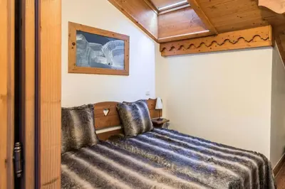 a bedroom with a bed and a wooden ceiling at Résidence Les Fermes du Soleil - maeva Home - Appartement 4 pièces 7 personnes Selection MAE-0493 in Les Carroz d'Araches