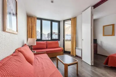 a living room with a red couch and a window at L'Aiguille - maeva Home - Appartement 2 pièces 5 personnes Confort MAE-7119 in Chamonix-Mont-Blanc