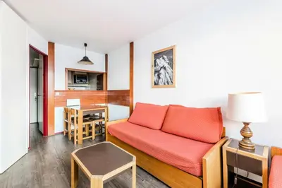 a living room with a red couch and a table at L'Aiguille - maeva Home - Appartement 2 pièces 5 personnes Confort MAE-7119 in Chamonix-Mont-Blanc