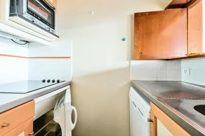 a small kitchen with a stove and a dishwasher at L'Aiguille - maeva Home - Appartement 2 pièces 5 personnes Confort MAE-7119 in Chamonix-Mont-Blanc