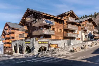 a large building with balconies on the side of a street at Résidence Les Fermes du Soleil - maeva Home - 3 pièces 6 pers Sélection MAE-5543 in Les Carroz d'Araches