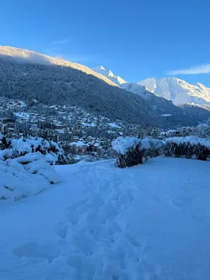 a snow covered city with mountains in the background at Appartement cosy, esprit chalet avec jolie vue in Saint-Gervais-les-Bains