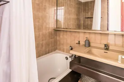a bathroom with a tub and a sink and a shower at L'Aiguille - maeva Home - Appartement 2 pièces 5 personnes Confort MAE-2197 in Chamonix-Mont-Blanc