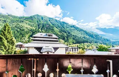 a view of a building with mountains in the background at L'Aiguille - maeva Home - 2 Pièces 5 Personnes Confort MAE-1176 in Chamonix-Mont-Blanc