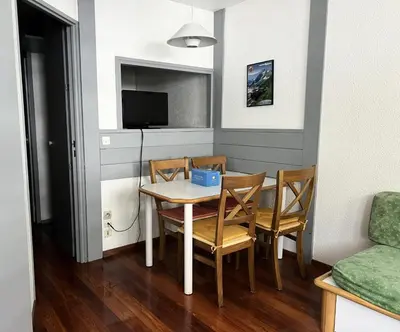 a dining room with a table and chairs and a television at L'Aiguille - maeva Home - 2 Pièces 5 Personnes Confort MAE-1176 in Chamonix-Mont-Blanc