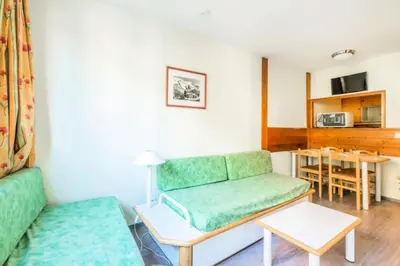 a living room with a green couch and a table at L'Aiguille - maeva Home - 2 Pièces 5 Personnes Confort MAE-2139 in Chamonix-Mont-Blanc