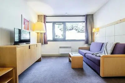 a living room with a couch and a tv at Résidence La Forêt - maeva Home - Appartement 2 Pièces 5 Personnes - Confort MAE-4236 in Flaine
