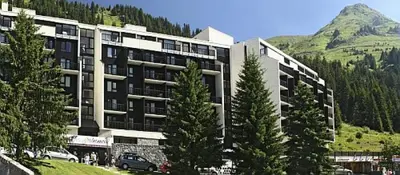 a large building with trees in front of a mountain at Résidence La Forêt - maeva Home - Appartement 2 Pièces 5 Personnes - Confort MAE-4236 in Flaine