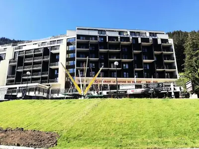 a large building with a green field in front of it at Résidence La Forêt - maeva Home - Appartement 2 Pièces 5 Personnes - Confort MAE-4236 in Flaine