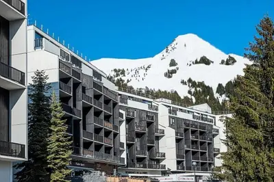 a building with a snow covered mountain in the background at Résidence La Forêt - maeva Home - Appartement 2 Pièces 5 Personnes - Confort MAE-4236 in Flaine