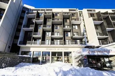 a building with a pile of snow in front of it at Résidence La Forêt - maeva Home - Appartement 2 Pièces 5 Personnes - Confort MAE-4236 in Flaine