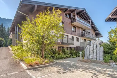 an apartment building with a tree in front of it at Appartement du Cerf - Welkeys in Megève