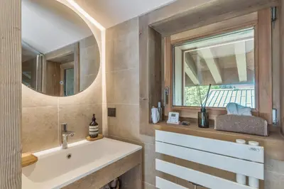 a bathroom with a sink and a window at Appartement du Cerf - Welkeys in Megève