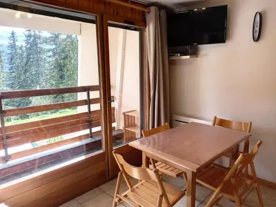 a dining room with a table and chairs and a window at Résidence Arche - Studio confortable · Centre station · Terrasse MAE-5084 in Magland